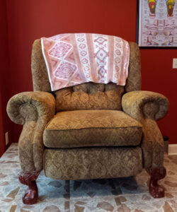 Front view of a reclining chair placed on raised floor in a room with red walls